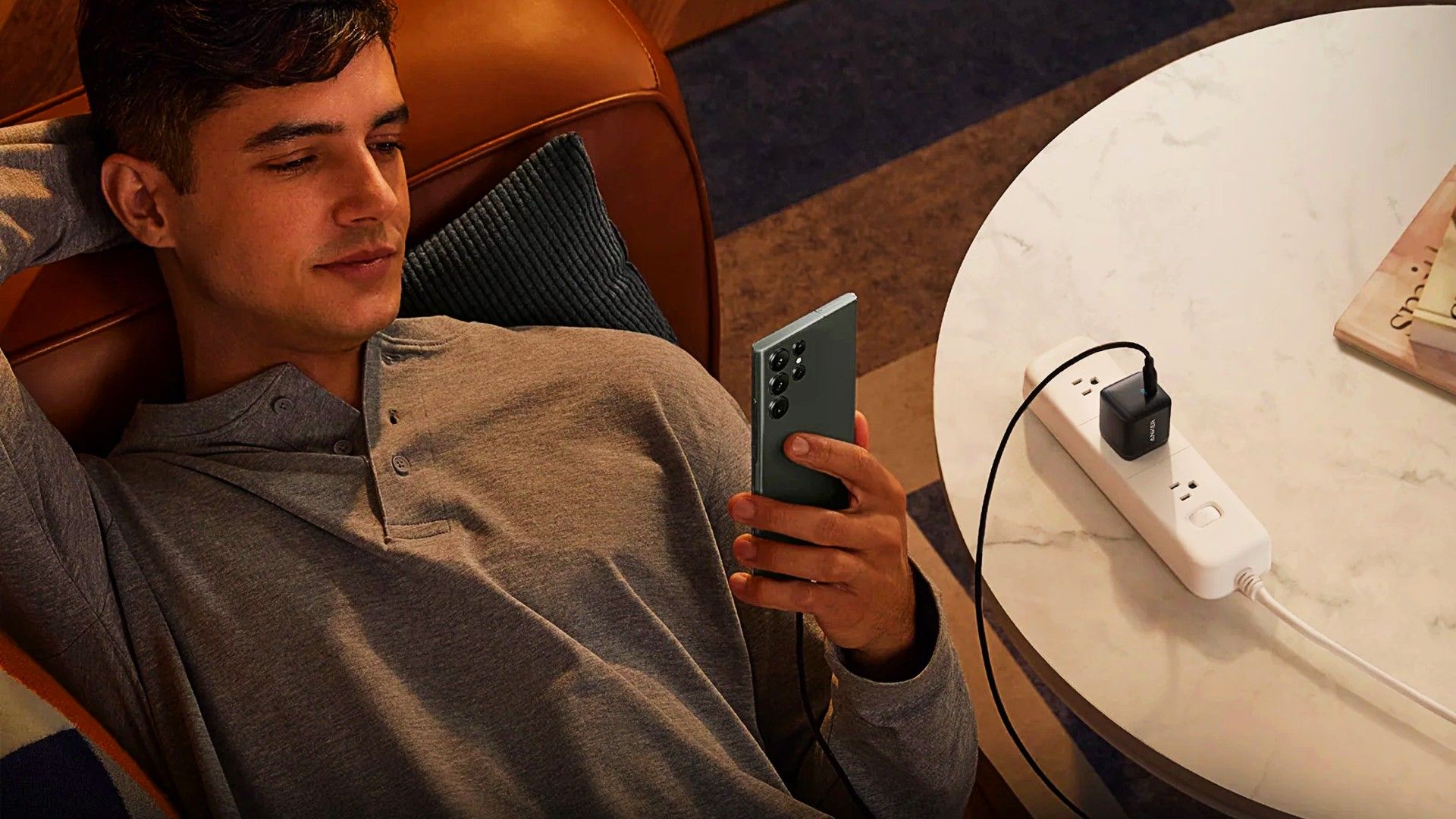anker-313-being-used-to-charge-a-phone-while-sopmeone-uses-it.jpg